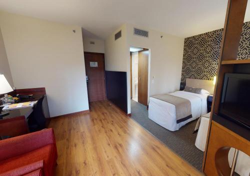 a hotel room with a bed and a television at Estanplaza Funchal Faria Lima in Sao Paulo