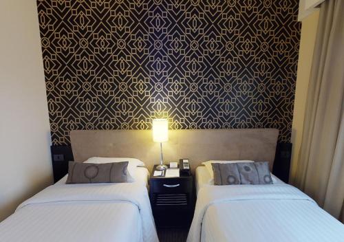 a hotel room with two beds and a wall mural at Estanplaza Funchal Faria Lima in Sao Paulo