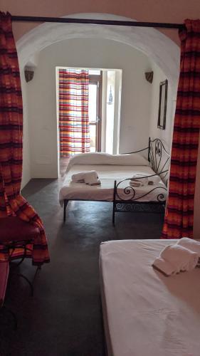 a bedroom with two beds and a window at Horizon Pantelleria in Pantelleria