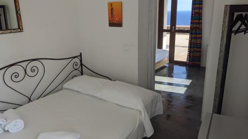 a bedroom with a white bed with a metal headboard at Horizon Pantelleria in Pantelleria