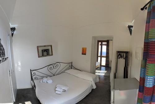 a bedroom with a white bed with towels on it at Horizon Pantelleria in Pantelleria