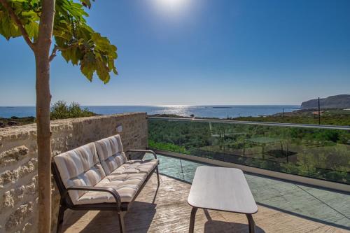 two chairs and a table on a balcony with the ocean at 2 steps Falasarna beach-Liakos- Homeleader in Falasarna