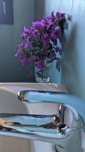 a vase of purple flowers sitting on top of a sink at Horizon Pantelleria in Pantelleria