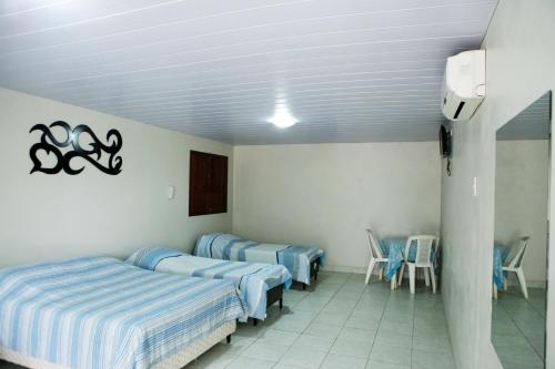 a room with three beds and chairs in it at Pousada Agreste Water Park in Caruaru