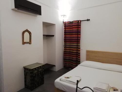 a small bedroom with a bed and a curtain at Horizon Pantelleria in Pantelleria