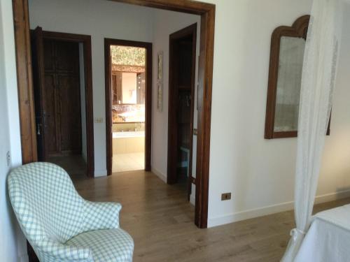 a living room with a chair and a mirror at B&B Casa Soresina in Offagna