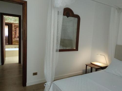 a bedroom with a bed and a mirror and a tub at B&B Casa Soresina in Offagna