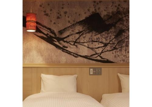 2 camas en una habitación con un cuadro en la pared en Sakura Sky Hotel - Vacation STAY 18444v, en Tokio
