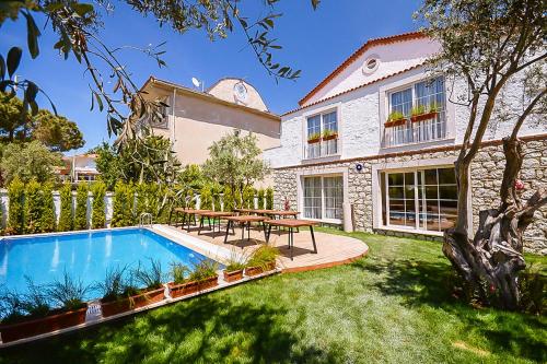 a house with a swimming pool and a picnic table at Rebetiko Hotel in Alaçatı