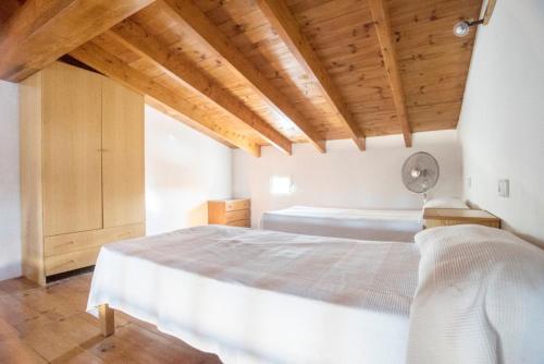 sypialnia z dużym łóżkiem i drewnianym sufitem w obiekcie CASA LAIA Cala Saona w mieście Cala Saona