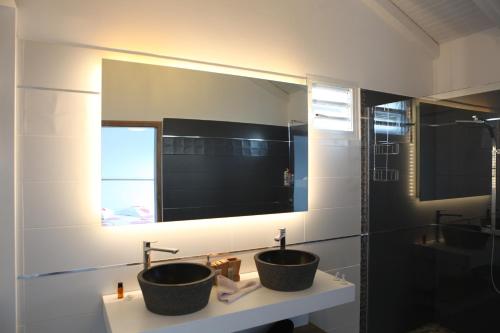 a bathroom with two sinks and a mirror at Villa Rubis in Le Moule