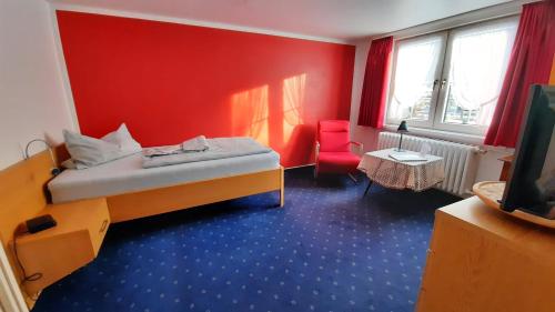 Haus Brigitte في باد لوتربرغ: غرفة صغيرة بها سرير وجدار احمر