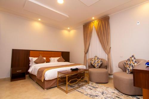 um quarto com uma cama, um sofá e uma mesa em ال متعب سويتس المرسلات em Riyadh