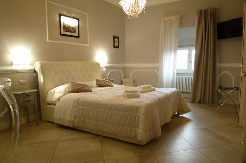 a bedroom with a white bed and a chandelier at Brunelleschi suite in Florence