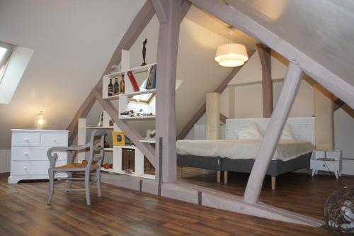 ein Schlafzimmer mit einem Bett im Dachgeschoss in der Unterkunft Le Moulin 1826 in Houdan