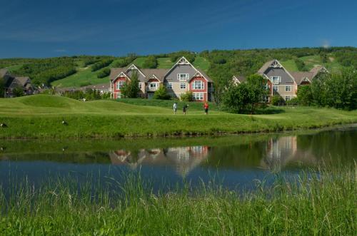 a group of houses next to a body of water at Blue Mountain Resort Home Collection in Blue Mountains