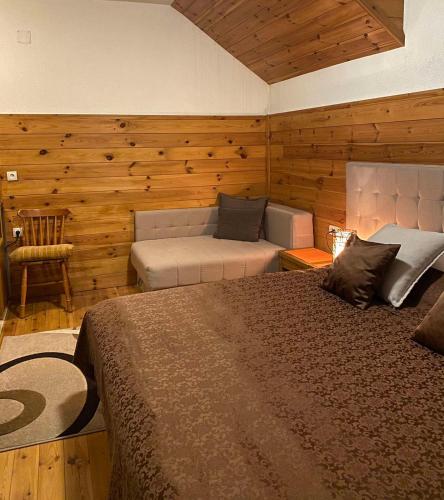 a bedroom with a bed and a couch in a room at Princess Nina Kolašin in Kolašin