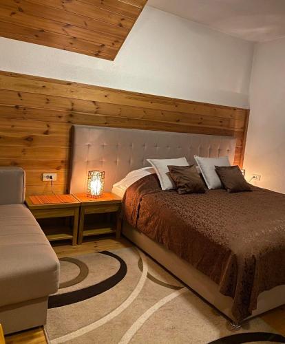 a bedroom with a bed and a table with a lamp at Princess Nina Kolašin in Kolašin