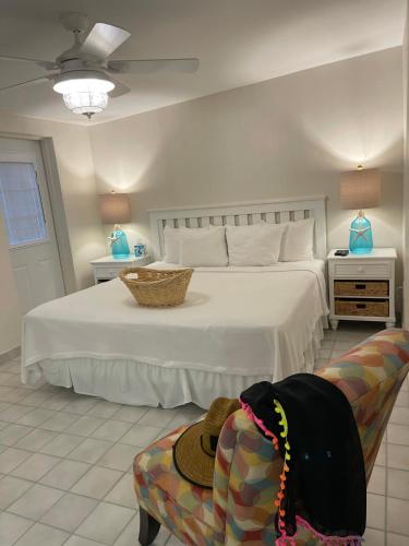 a bedroom with a bed and a chair with a hat on it at Cedar Cove Resort & Cottages in Holmes Beach