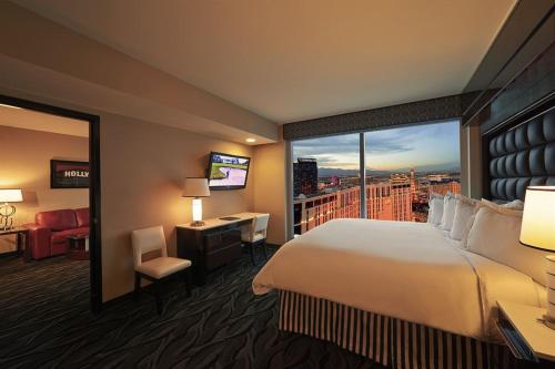 a hotel room with a large bed and a large window at Suites at Elara Las Vegas Center Strip-No Resort Fees in Las Vegas