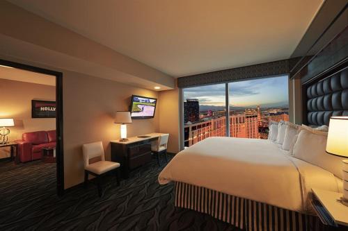 a hotel room with a large bed and a large window at Suites at Elara Las Vegas Strip-No Resort Fees in Las Vegas