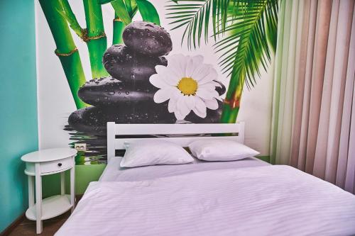a bedroom with a bed with a flower on the wall at Ангел комфорт in Kyiv