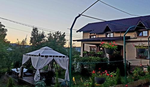 a gazebo in a garden in front of a house at Vila Magnolia in Curtea de Argeş