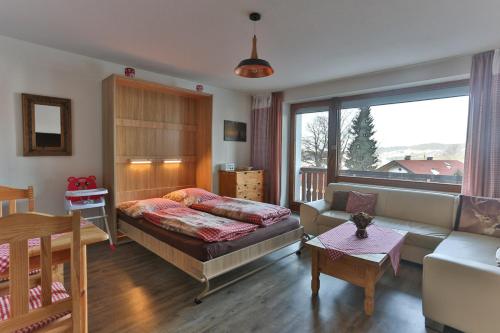 een woonkamer met een bed en een bank bij Ferienwohnung Alpenfreude in Missen-Wilhams