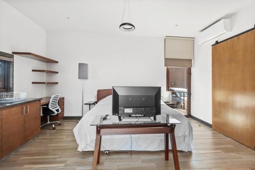 a room with a bed and a computer on a table at +MS +Suite Loft Accesible +Ubicadísimo +Carretera 57 105A in Querétaro