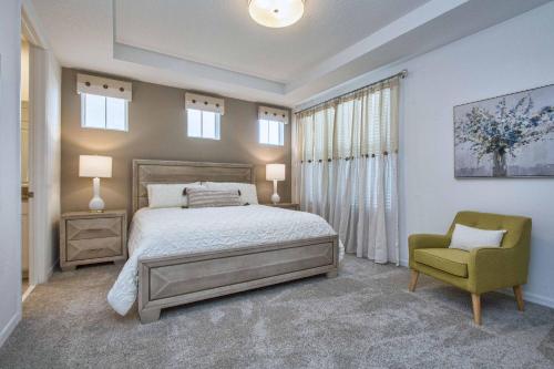 1 dormitorio con 1 cama y 1 silla verde en 5 Bedrooms Townhome w- Splashpool - 8205SA en Orlando