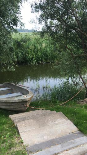 een boot op een dok naast een waterlichaam bij Iris't; Dijkhuisje in de polders van Groede. in Groede