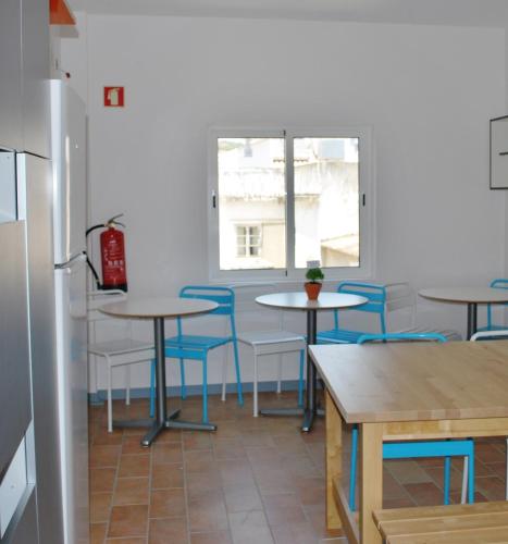 a room with tables and chairs and a window at Peneco Albufeira GuestHouse in Albufeira