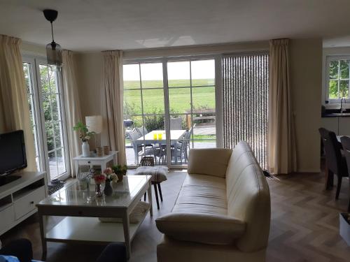 a living room with a couch and a table at Nieuwe Beachbungalow aan IJsselmeer 39 24 four seasons in Lemmer