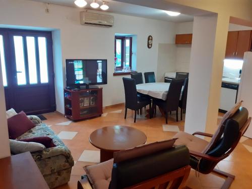 ein Wohnzimmer mit einem Sofa und einem Tisch mit Stühlen in der Unterkunft Rest House Stiniva in Podšpilje