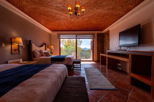 een hotelkamer met 2 bedden en een televisie bij Hotel Camino de Vinos in Guanajuato