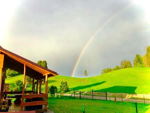 a rainbow in the sky over a green field at Domki Eden Kaszuby balia sauna alpaki mini zoo in Gołubie