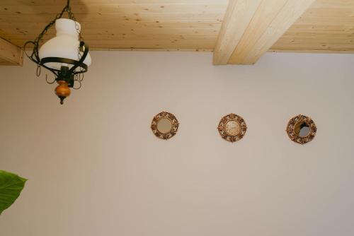 a chandelier and two plates on a wall at Rai pe Vale Boutique & Spa in Leordina