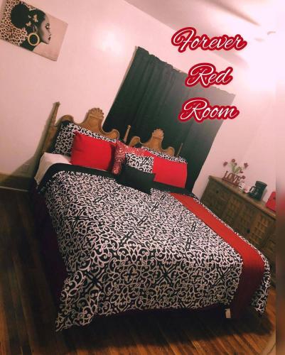 
a bed room with a red bedspread and pillows at The Collective House {Cannabis Friendly} in Highland Park
