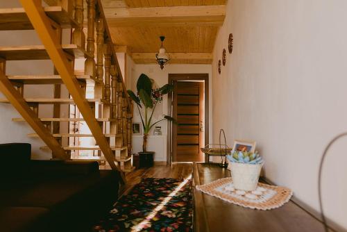 a living room with a staircase and a rug at Rai pe Vale Boutique & Spa in Leordina