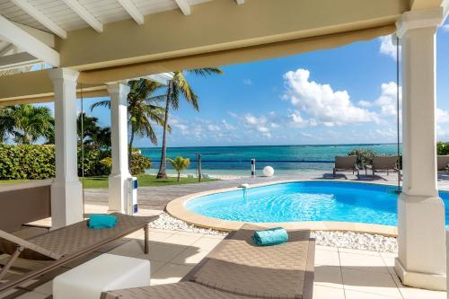 una piscina con vista sull'oceano di Villa Marine 5 étoiles sur la plage du lagon à deux pas du golf a Saint-François