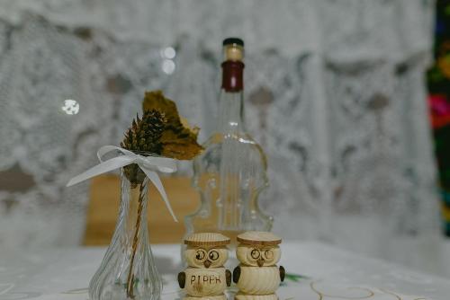 a bottle of wine and a vase with a flower at Rai pe Vale Boutique & Spa in Leordina
