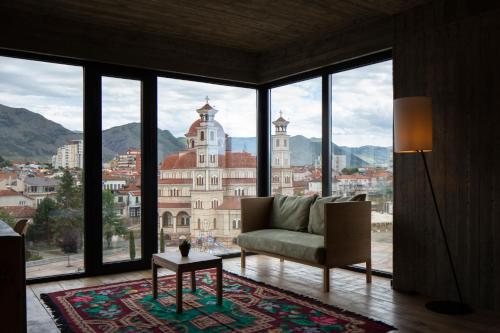 sala de estar con sofá y ventana grande en IN Gallery Hotel & Spa, en Korçë