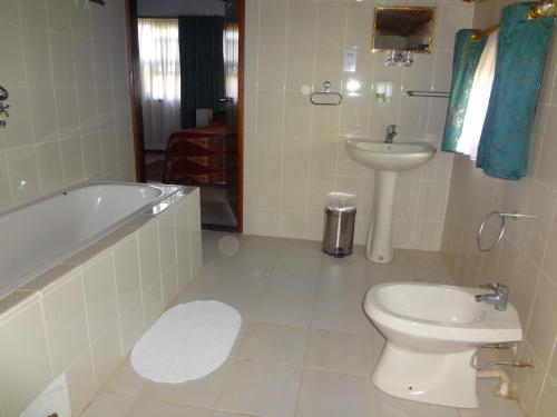 a bathroom with a tub and a toilet and a sink at Roc Heights in Bakau