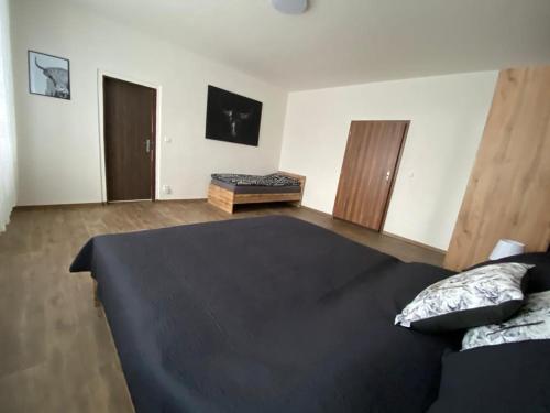 ein Schlafzimmer mit einem schwarzen Bett in einem Zimmer in der Unterkunft Apartmány Černý Tulipán 3 in Pilsen