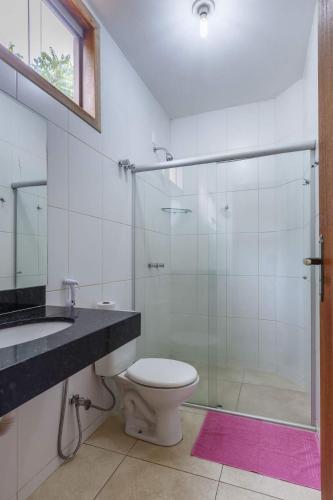 a bathroom with a toilet and a glass shower at Estancia do Vale in Serra do Cipo