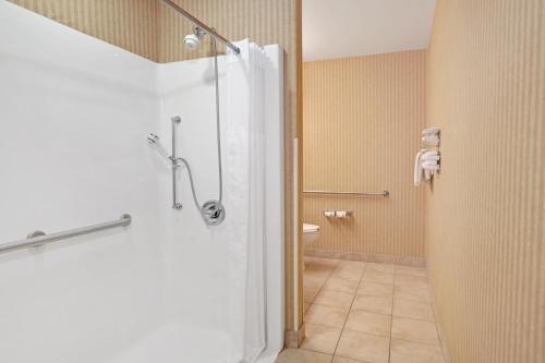 a bathroom with a shower with a glass door at Microtel Inn & Suites by Wyndham Charleston in Charleston