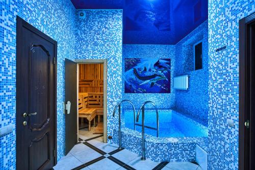 - une salle de bains pourvue de carrelage bleu et d'une baignoire dans la chambre dans l'établissement Ангел комфорт, à Kiev