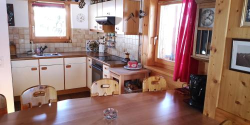 a kitchen with wooden cabinets and a wooden table and chairs at grosses Ferienhaus mit Sauna im Skigeb. Obersaxen in Obersaxen