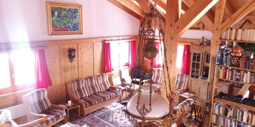 a living room with a couch and a table and chairs at grosses Ferienhaus mit Sauna im Skigeb. Obersaxen in Obersaxen