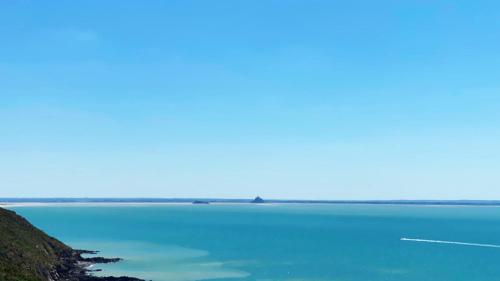 a view of the blue water of a lake at Maison de La Beslière meublé de tourisme 2 étoiles in Folligny